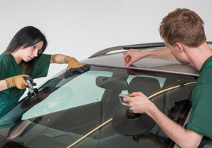 experts taking a look to windshield replacement of a customers car
