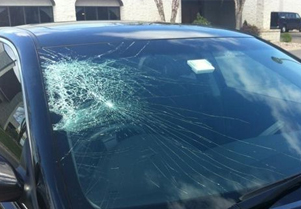 A car faced accident and a cracked windshield shown in image